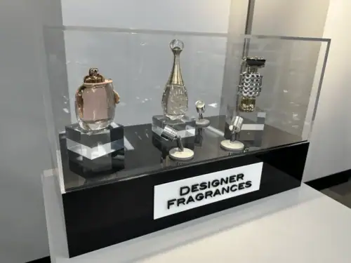 Black and Clear Acrylic Riser Displaying Designer Fragrance Bottles in a Glass Showcase