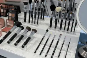 White Acrylic Risers Displaying Rows Of Makeup Brushes On A Cosmetics Counter