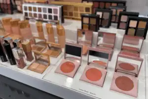 Clear Acrylic Risers Presenting Makeup Palettes And Cosmetics On A Retail Counter