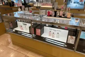 Acrylic Risers And Branded Cards Presenting Perfumes Inside A Glass Display Counter