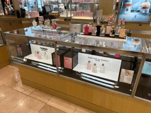 Acrylic Risers and Branded Cards Presenting Perfumes Inside a Glass Display Counter