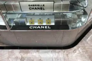 Curved Stone-Look Cosmetics Counter With Chanel Branding And Glass Display Top