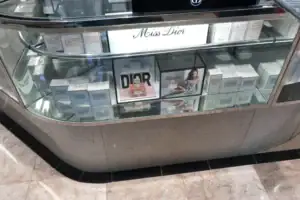 Curved Cosmetics Counter With Dior Branding, Glass Showcase And Stone-Look Base