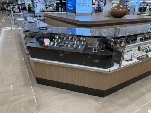 Angled Glass Watch Display Counter With Branded Interior in a Department Store