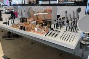 White Counter Display With Acrylic Holders Presenting Sigma Makeup Brushes And Cosmetics