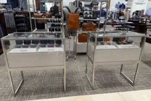 Metal-Framed Glass Display Cases With Fabric-Wrapped Bases On A Retail Floor