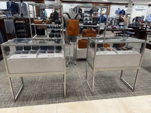Metal-Framed Glass Display Cases With Fabric-Wrapped Bases on a Retail Floor