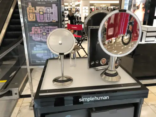 Black Counter Display Presenting Simplehuman Lighted Mirrors in a Department Store