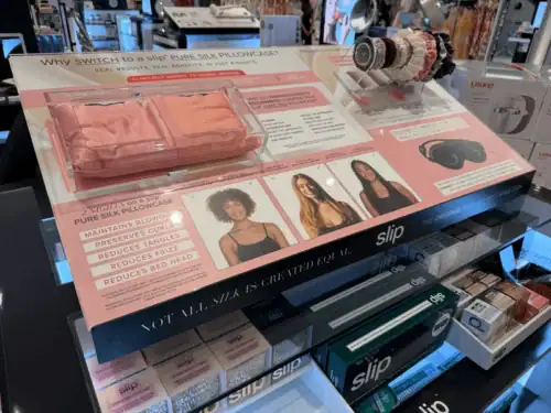 Counter Display With Printed Graphics Presenting Slip Silk Pillowcases and Hair Accessories