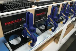 Retail Merchandising Fixture With Molded Product Clips Displayed Along A Store Shelf Rail