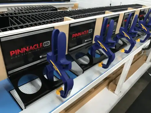 Retail Merchandising Fixture With Molded Product Clips Displayed Along a Store Shelf Rail