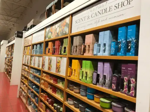 Wood Retail Shelving Aisle With Graphic Headers in a Scent and Candle Shop